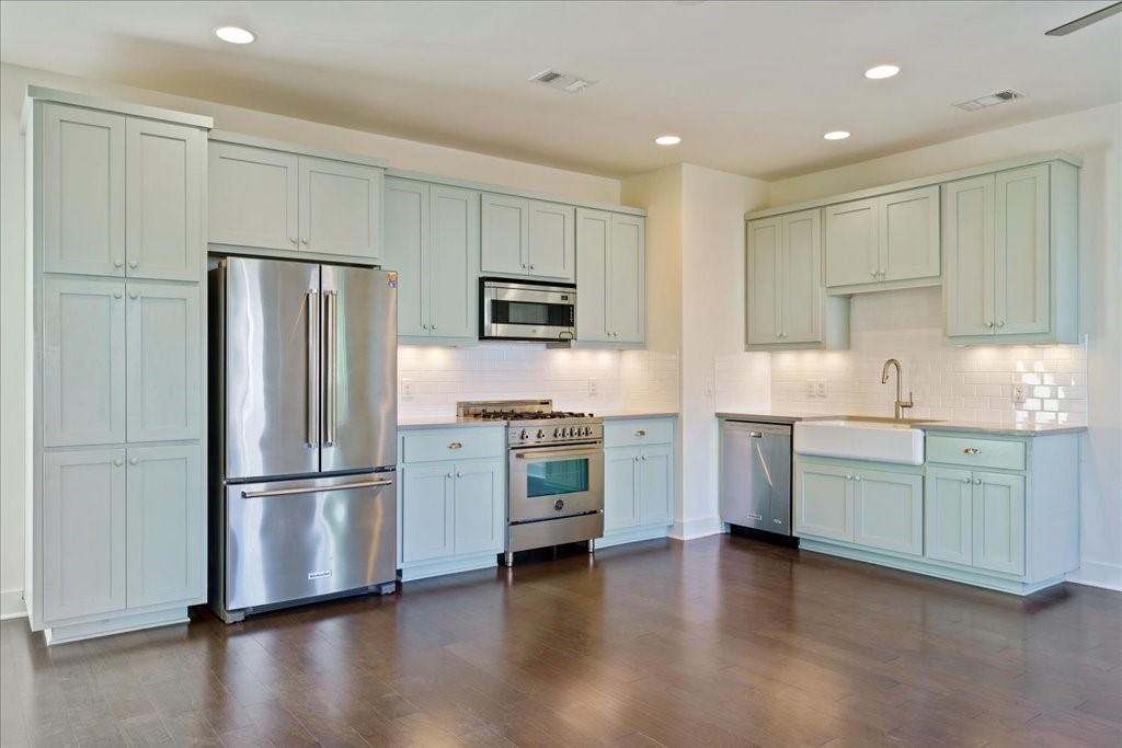 a kitchen with granite countertop white cabinets and stainless steel appliances