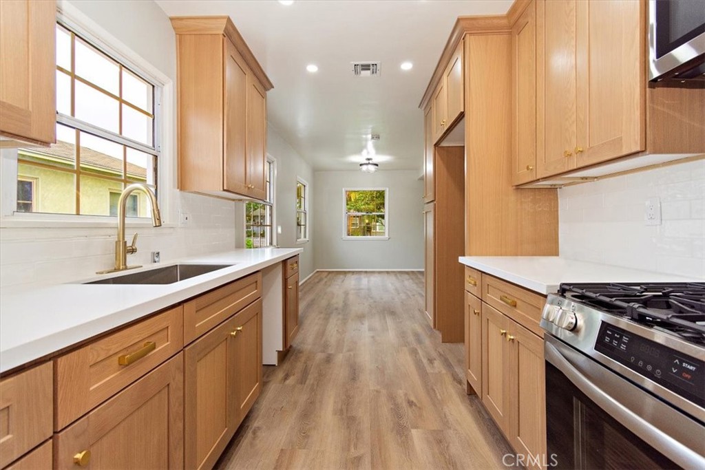 a kitchen with stainless steel appliances a sink stove and cabinets