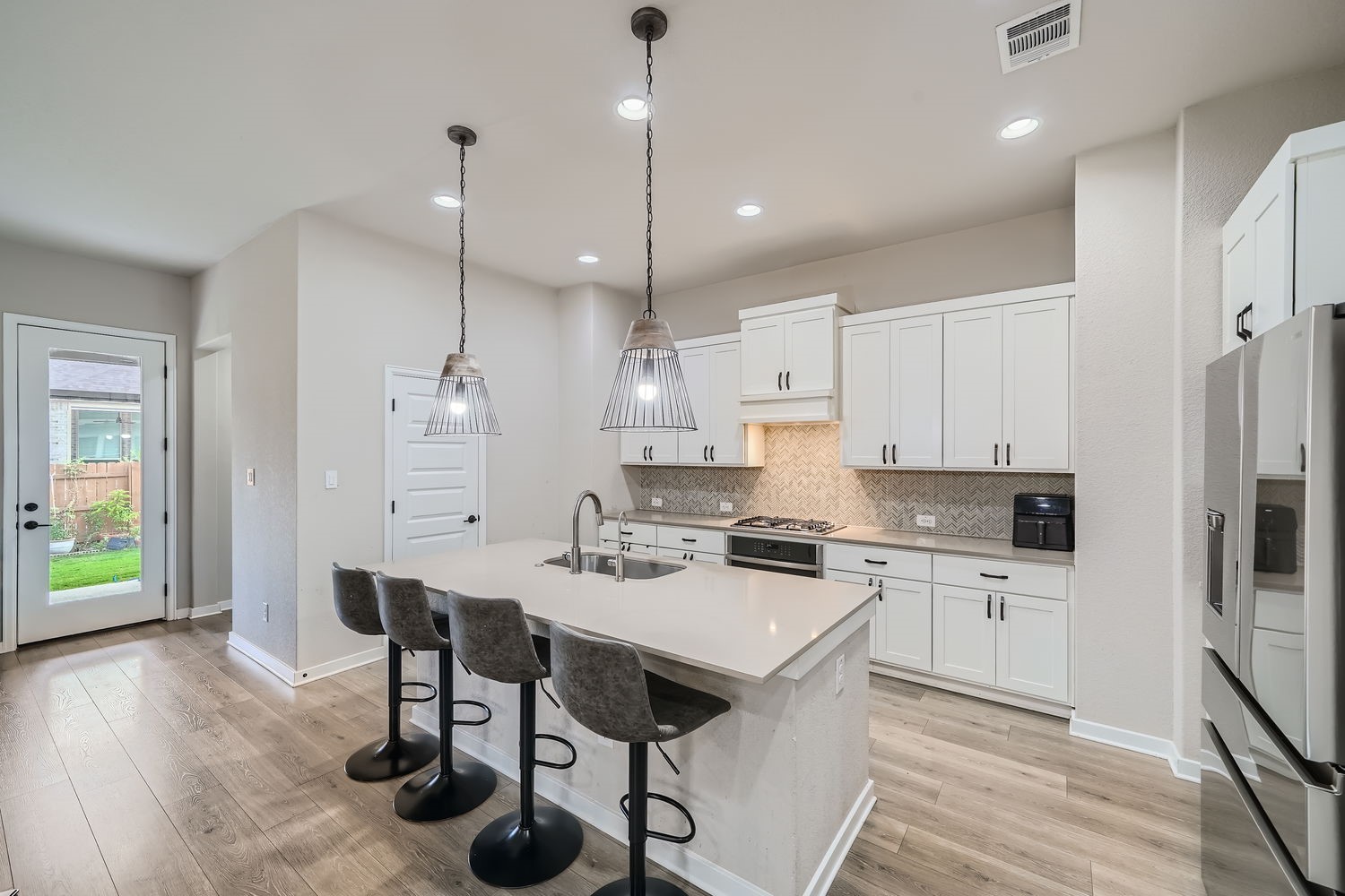 a kitchen with a dining table chairs sink and cabinets