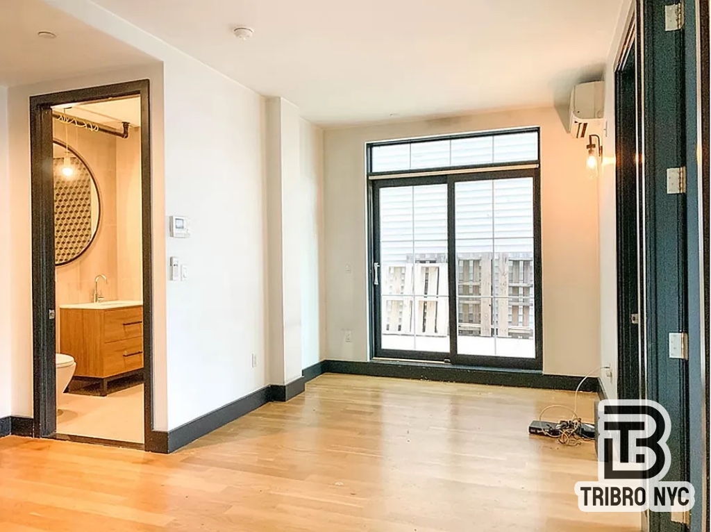 a view of a livingroom with wooden floor and a window