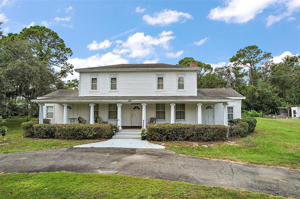 a front view of house with yard and green space