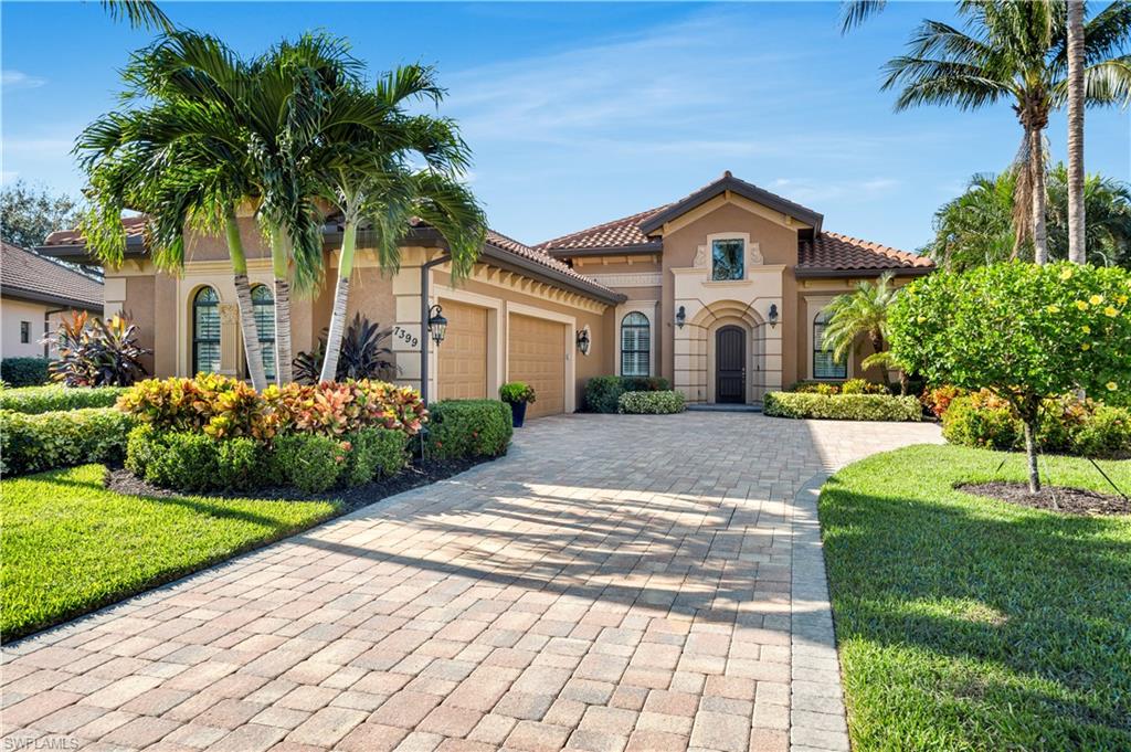 a front view of a house with a yard and potted plants