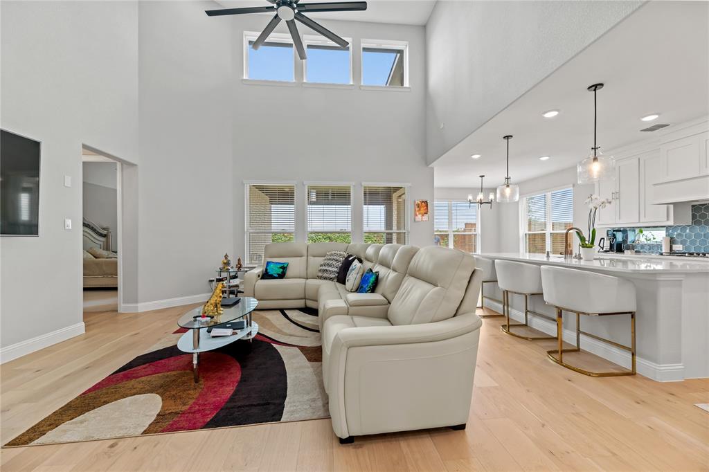 a living room with furniture kitchen view and a wooden floor