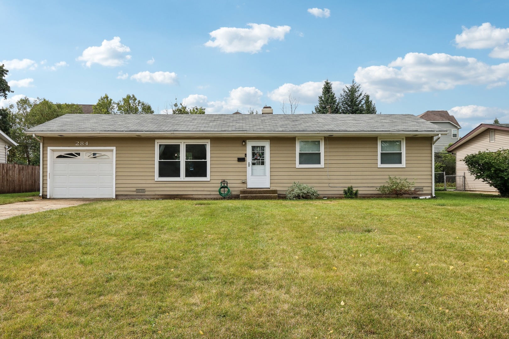 a front view of house with yard and trees