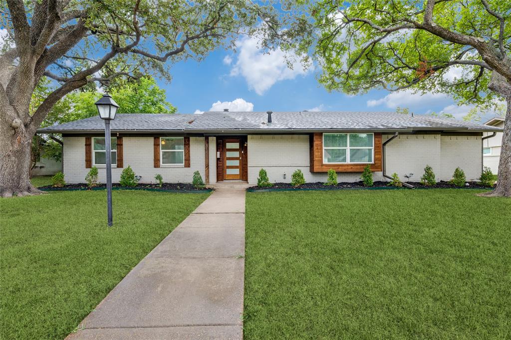 a front view of a house with a yard and trees