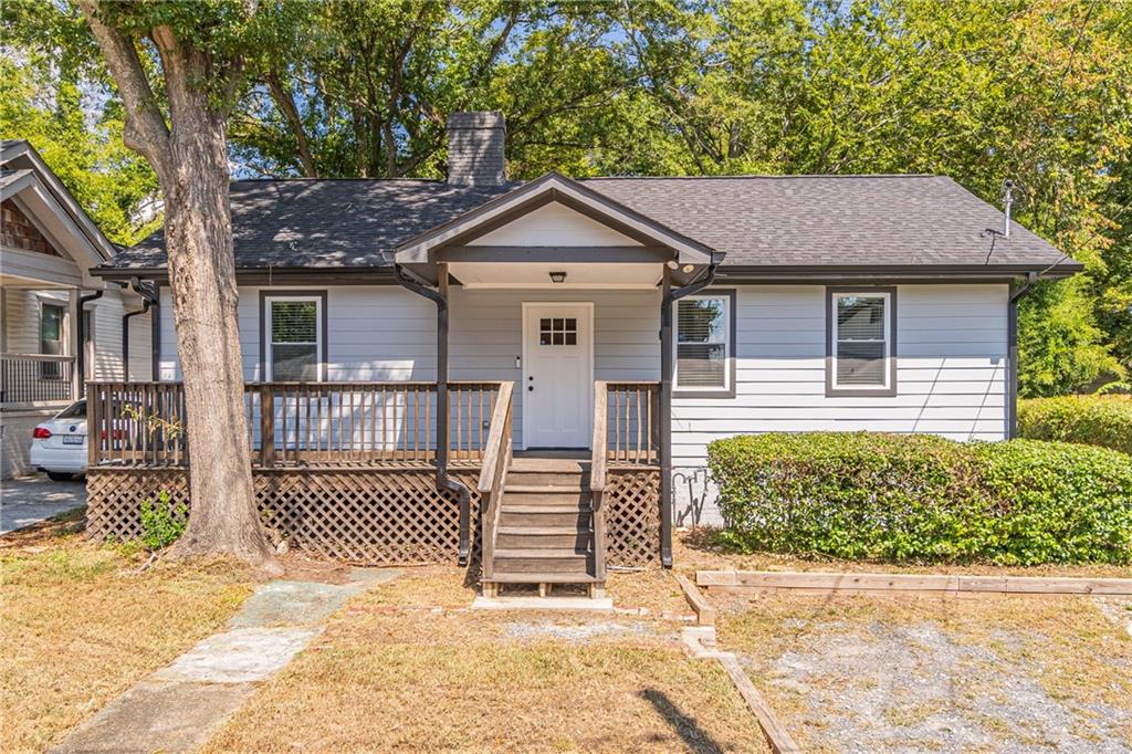 a view of a house with a small yard and wooden fence