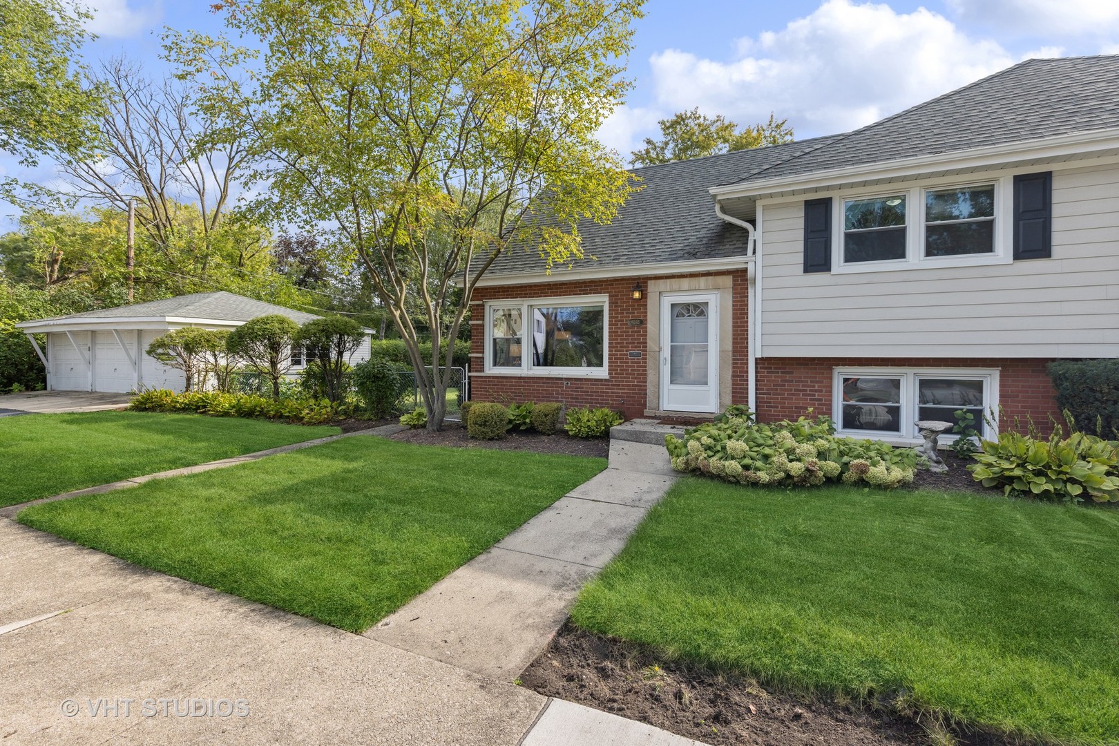 a front view of house with yard and green space