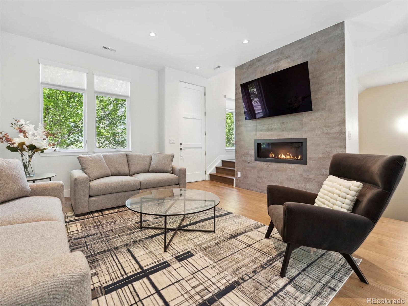 a living room with furniture a flat screen tv and a fireplace