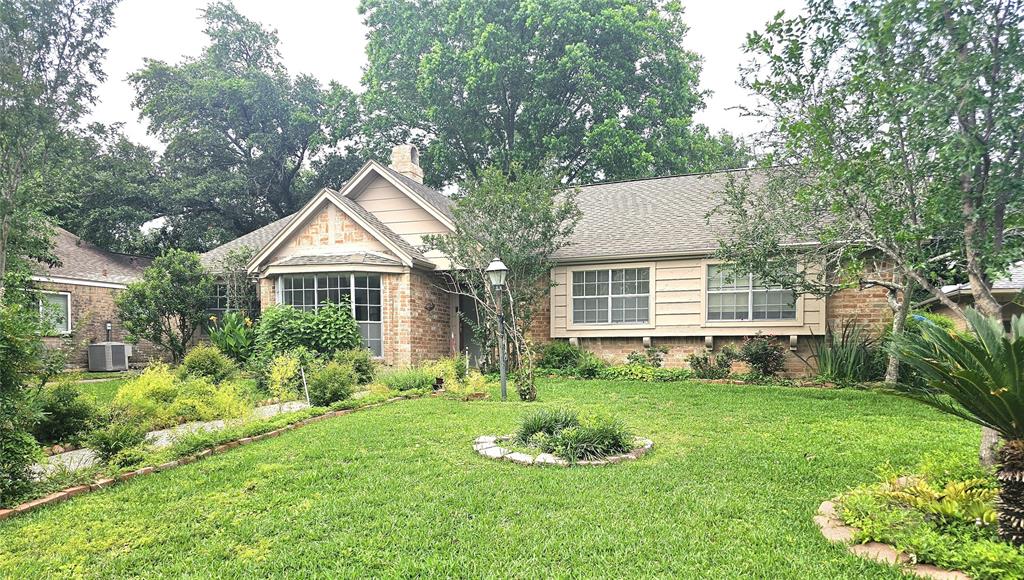 a front view of a house with a yard and trees