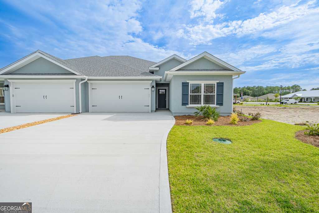 a front view of a house with yard and green space