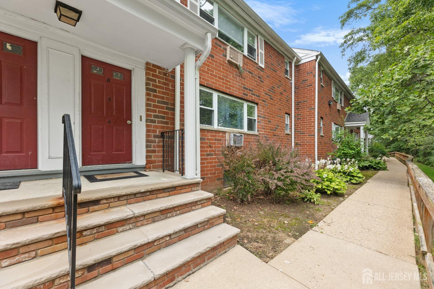 a view of a house with a door and a flower garden