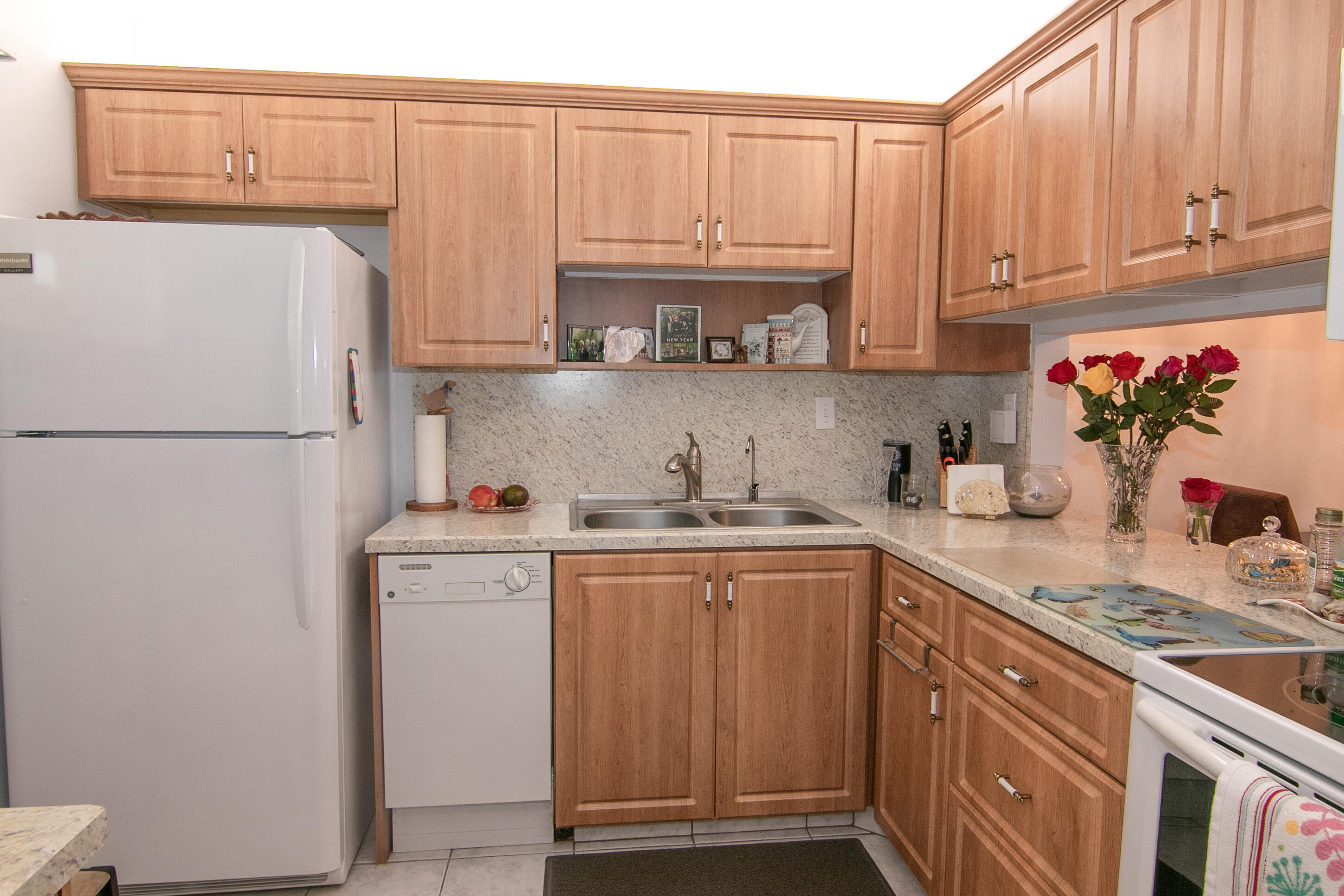 a kitchen with a sink a refrigerator and cabinets