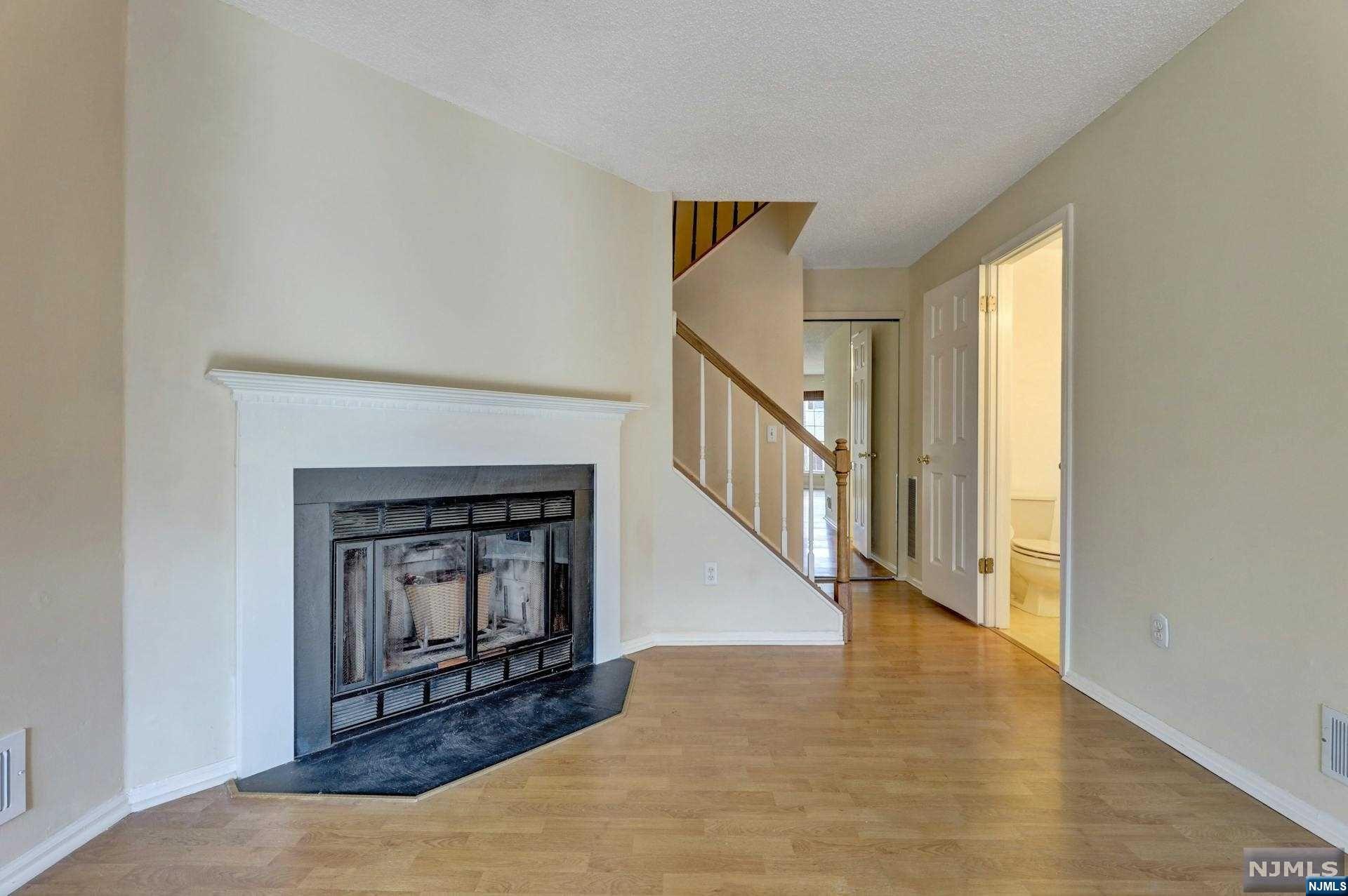 a view of a livingroom with wooden floor and a fireplace