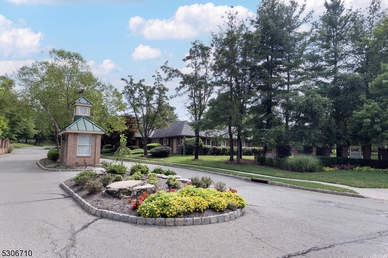 a front view of a house with a garden and trees