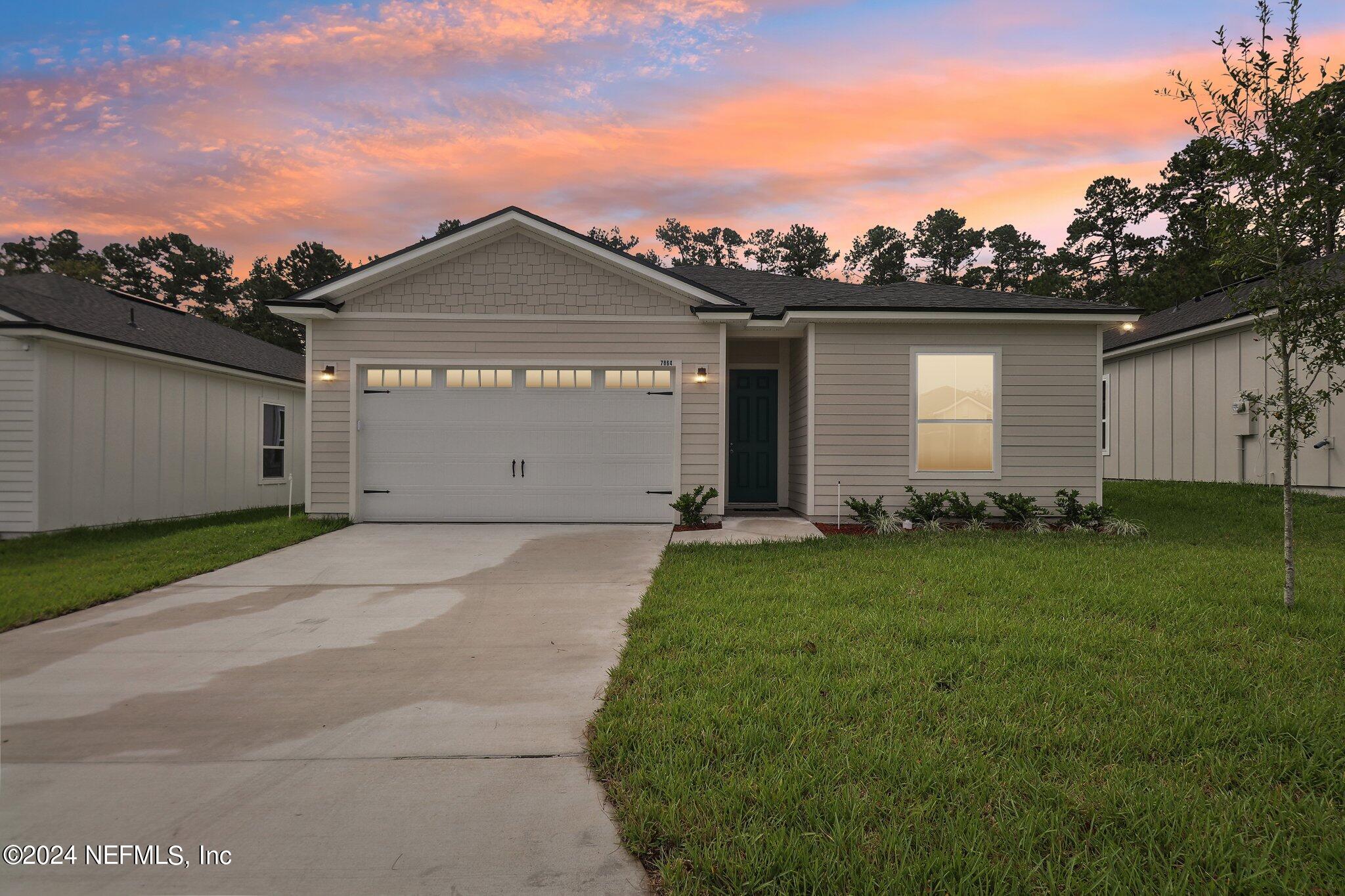 a view of a house with a yard and garage