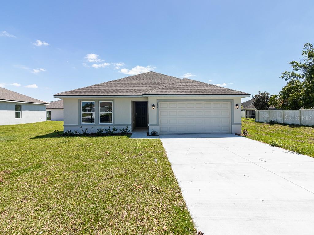 a front view of a house with a garden and yard