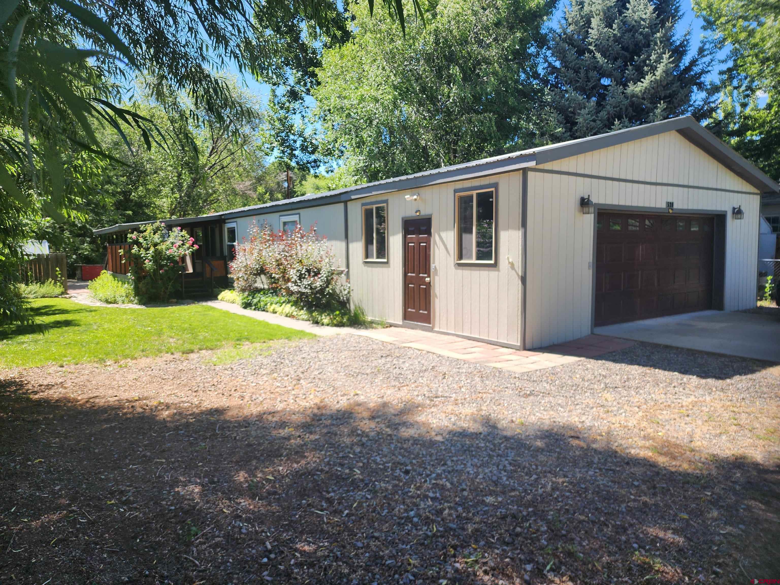 a view of a house with backyard and trees