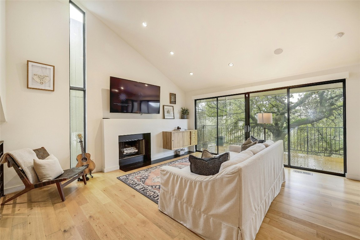 a living room with furniture a fireplace and a flat screen tv