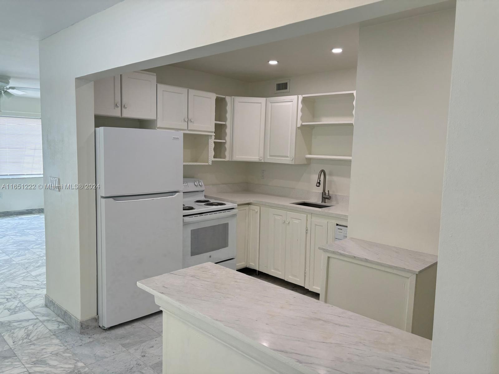 a kitchen with a refrigerator sink and cabinets