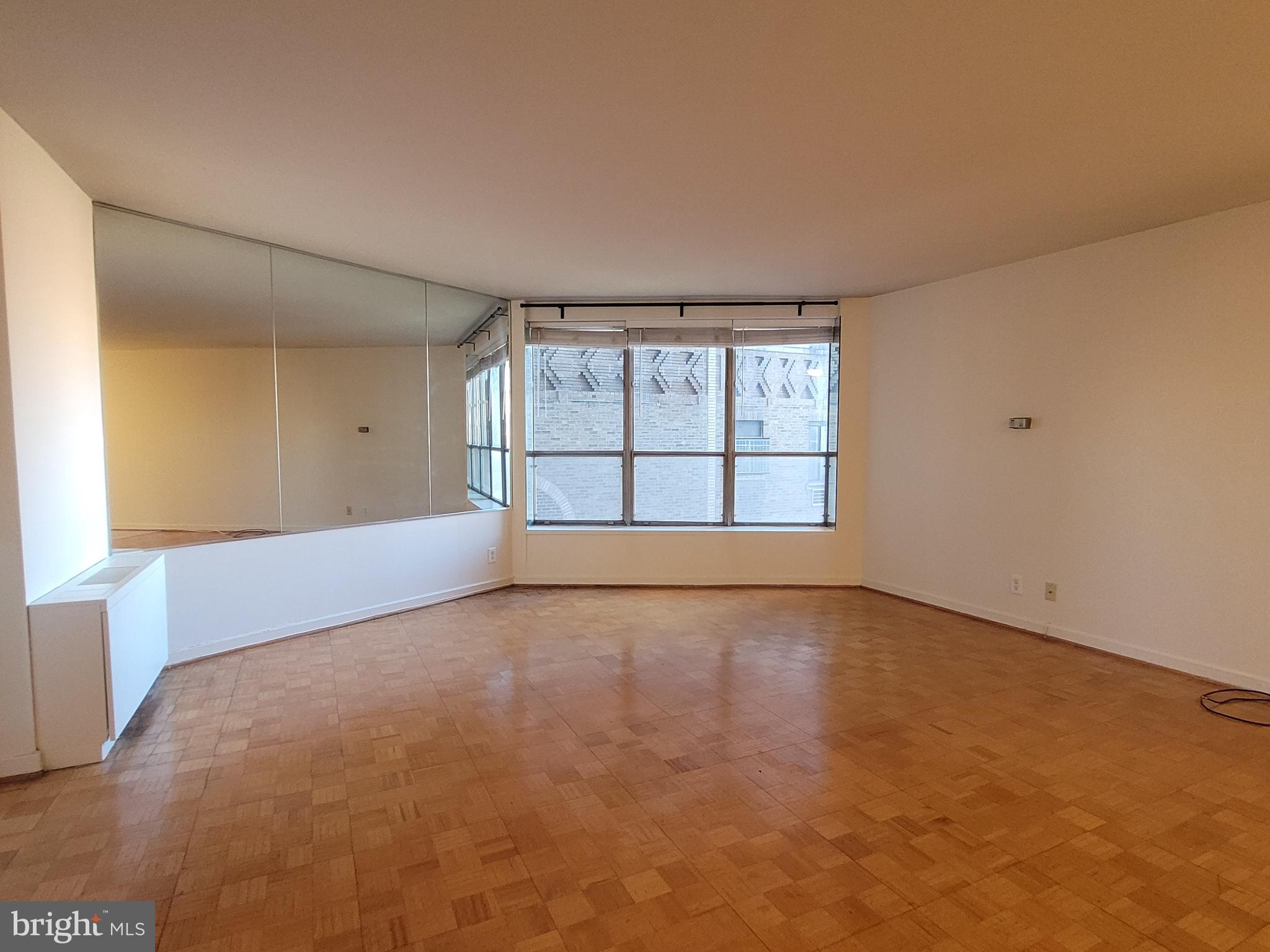 wooden floor in an empty room with a window