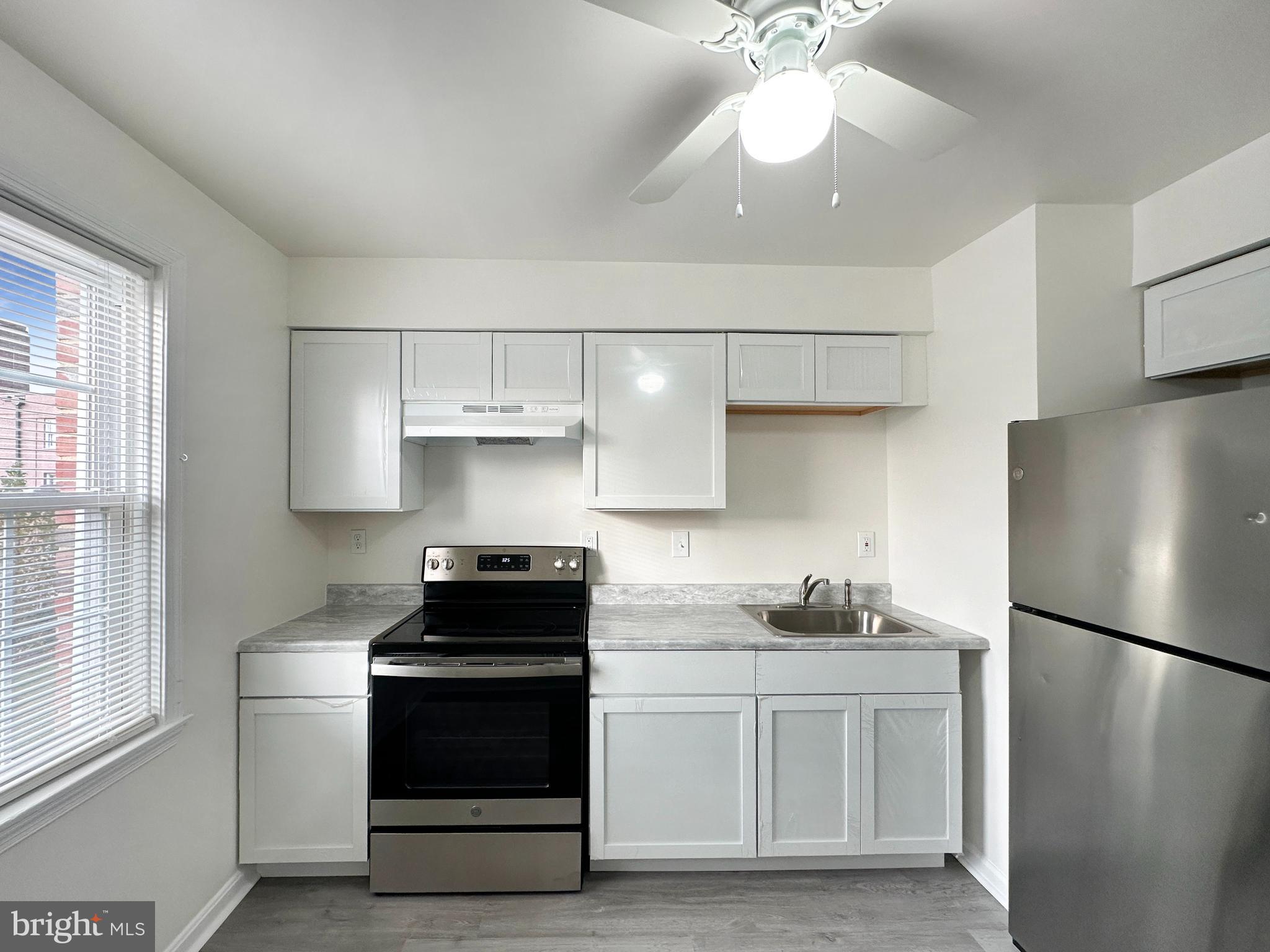 a kitchen with a refrigerator and a stove