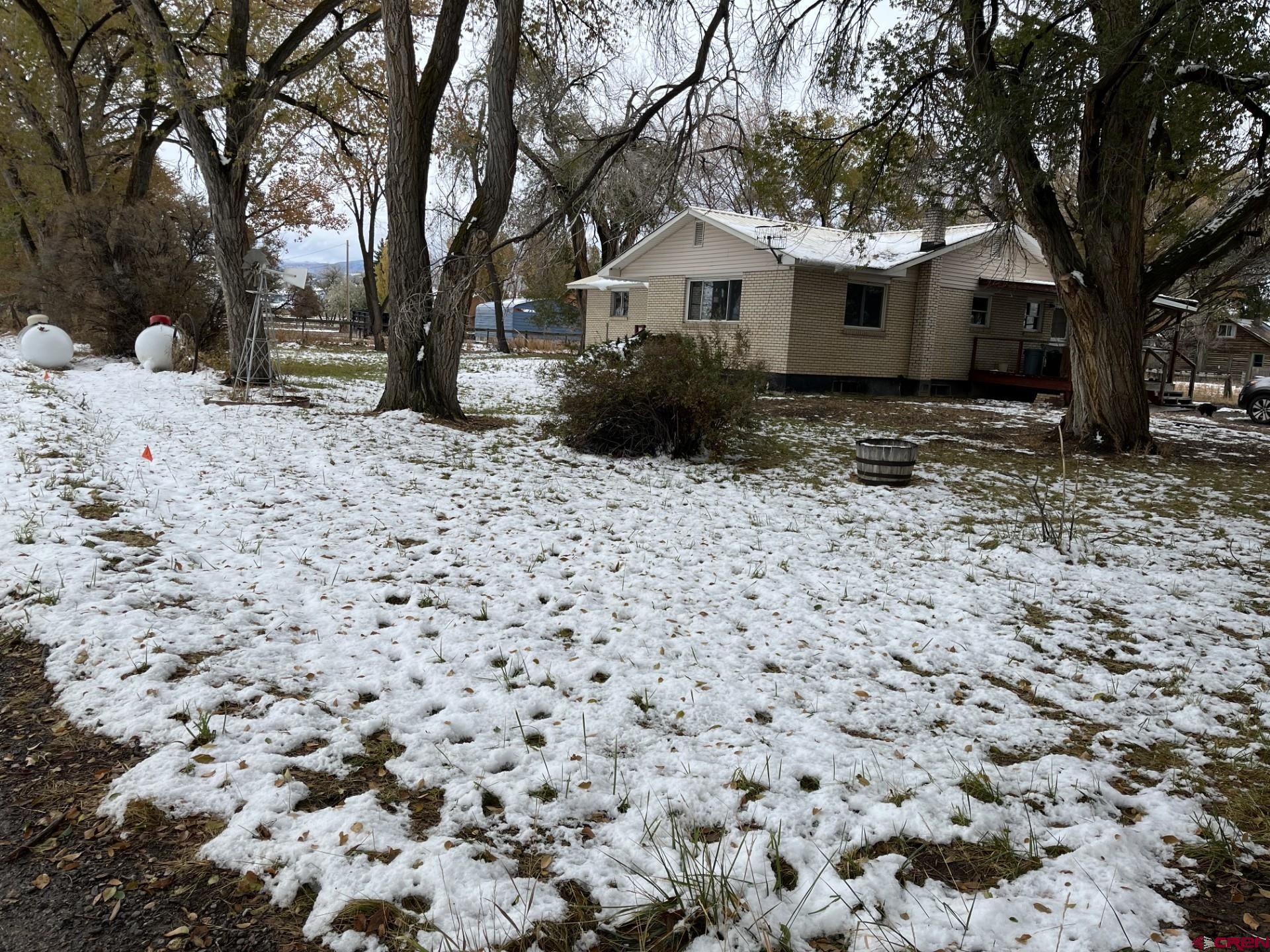 a view of a house with a yard covered with snow