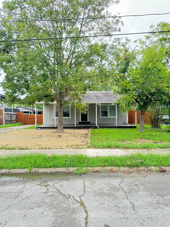 a front view of a house with a garden and trees