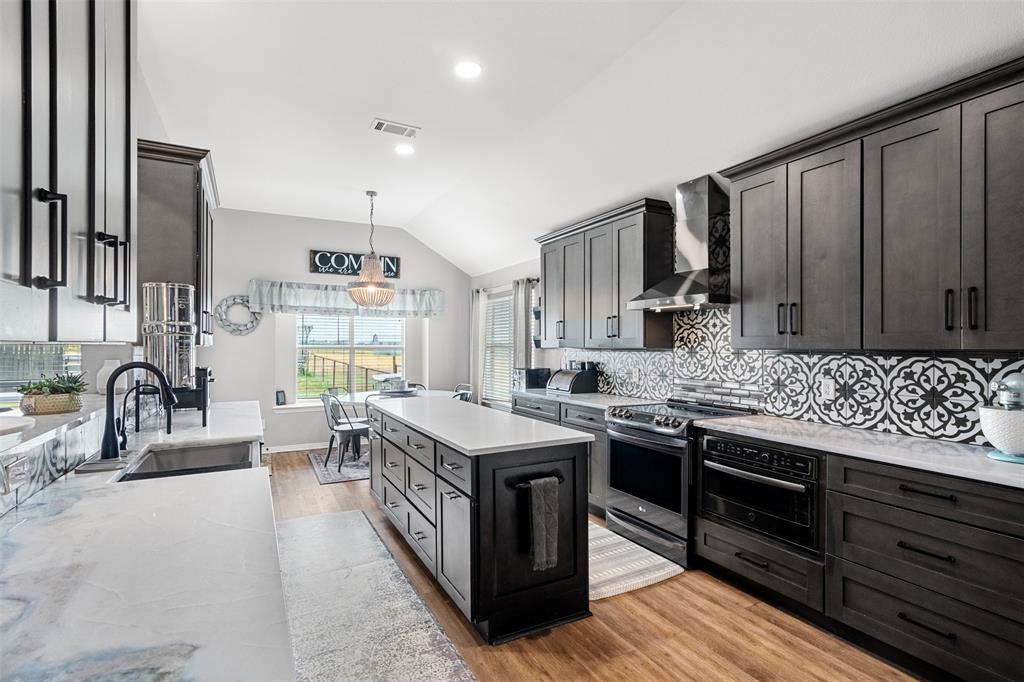 a kitchen with sink stove and cabinets