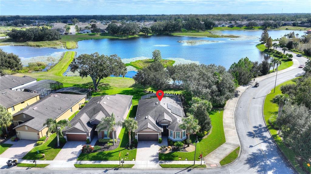 an aerial view of residential houses with outdoor space and lake view