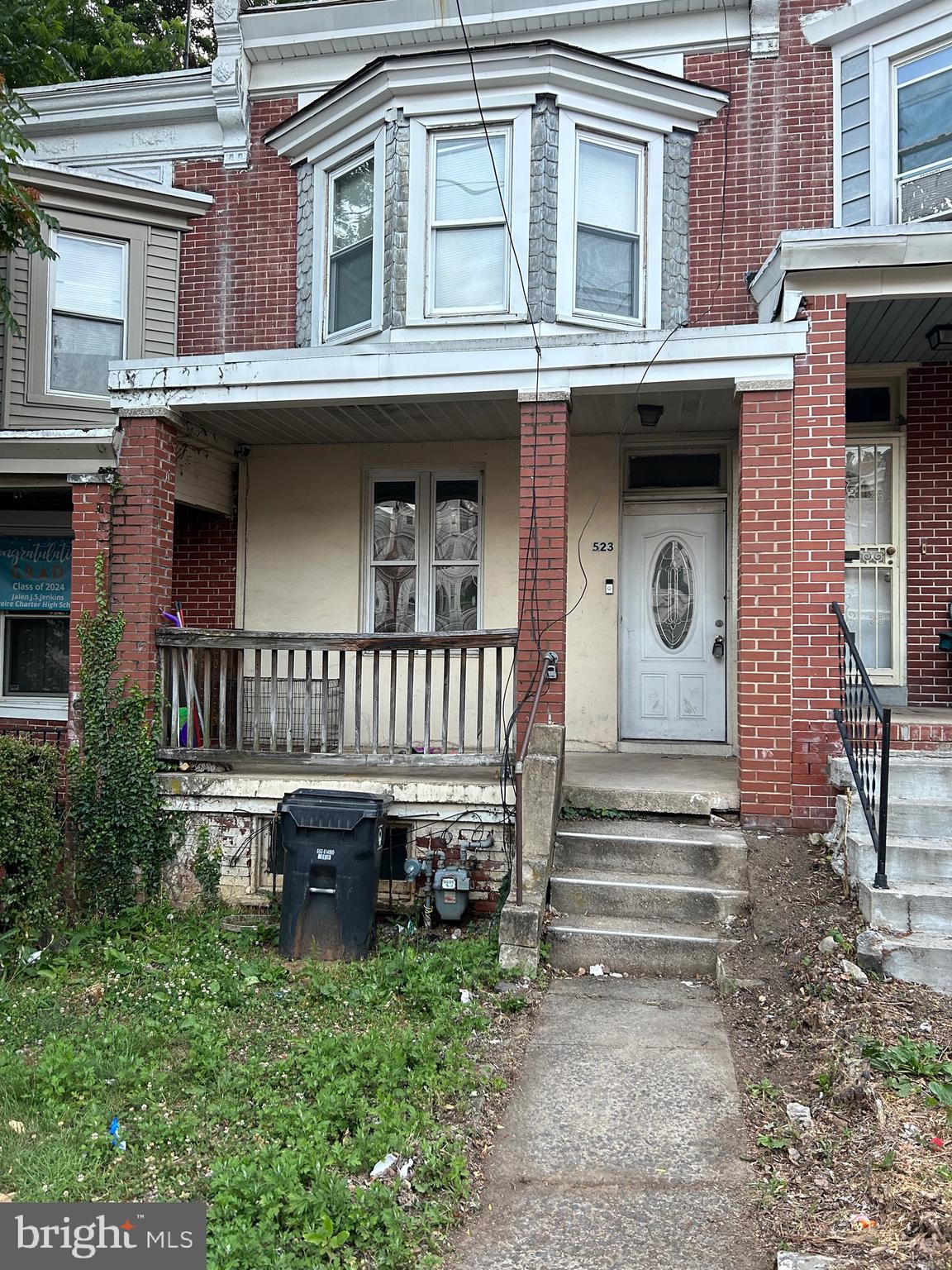 a view of a house with a small yard and large wooden fence