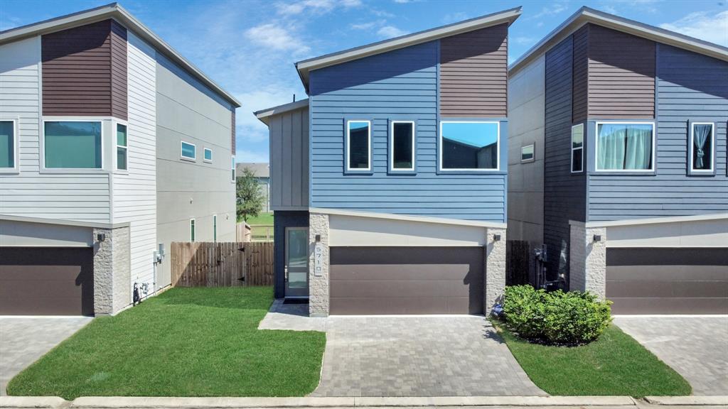 a front view of a house with a garden and garage