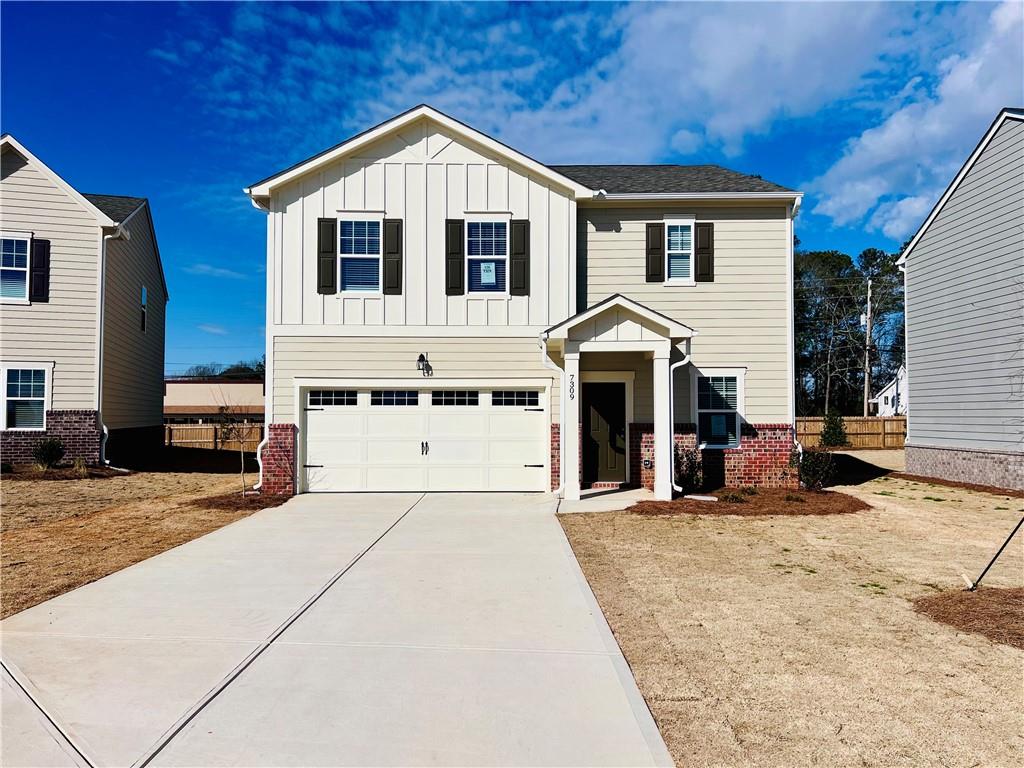 a front view of a house with a yard outdoor seating and garage