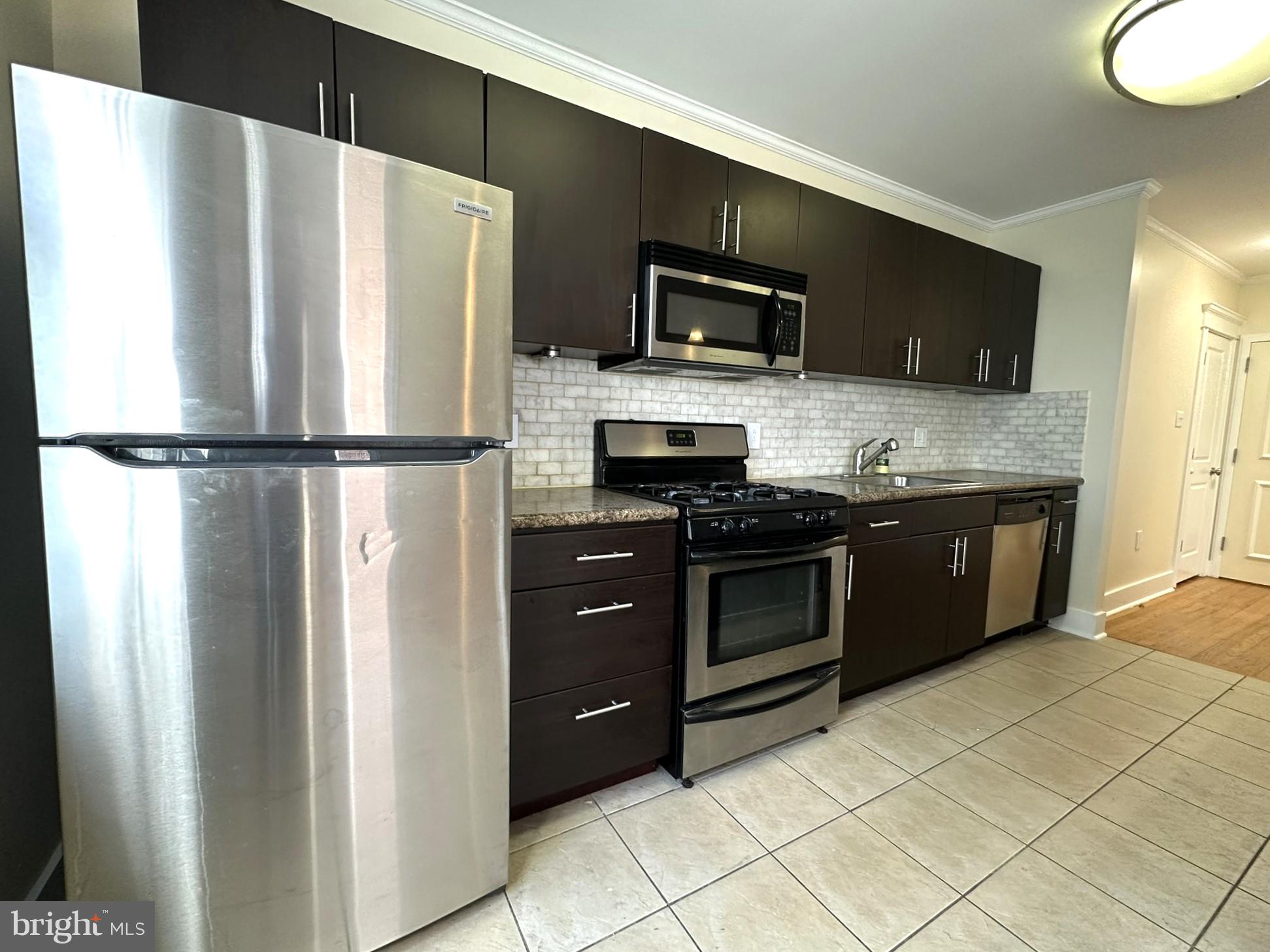 a kitchen with stainless steel appliances a refrigerator stove and microwave