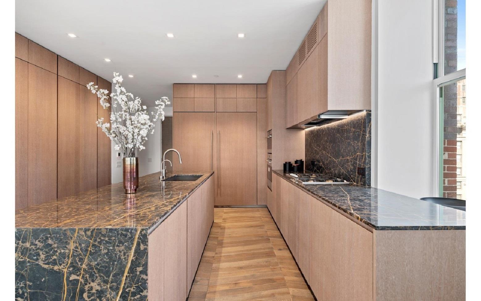 a kitchen with kitchen island granite countertop a sink refrigerator and microwave