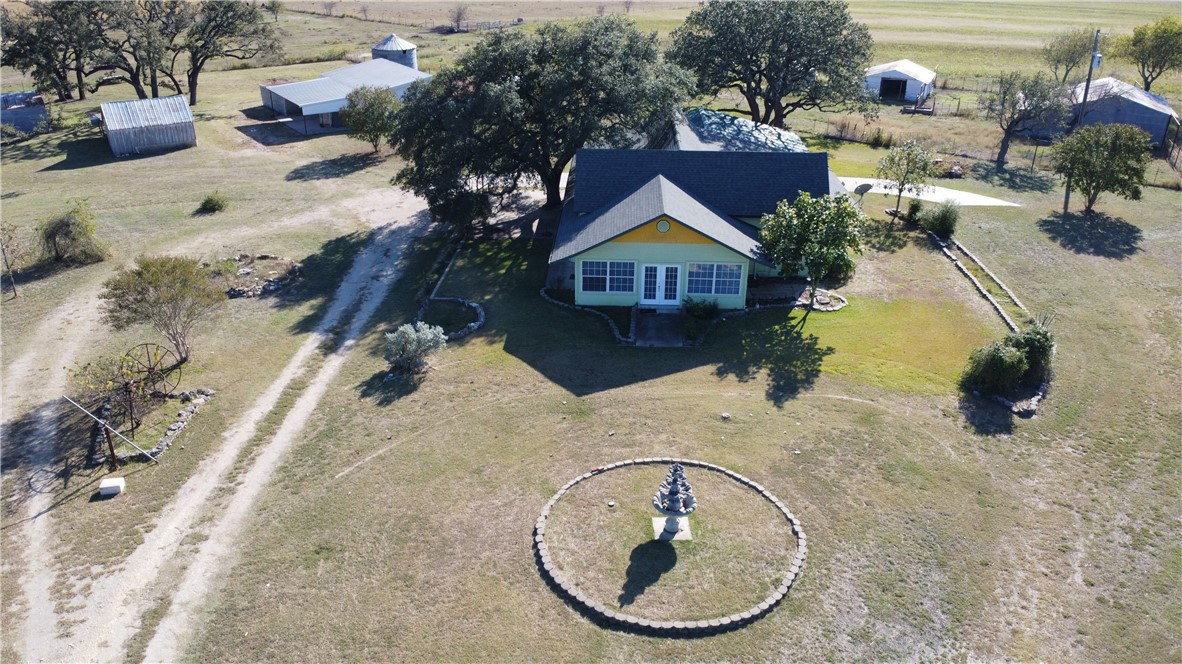 an aerial view of a house with a swimming pool and trees