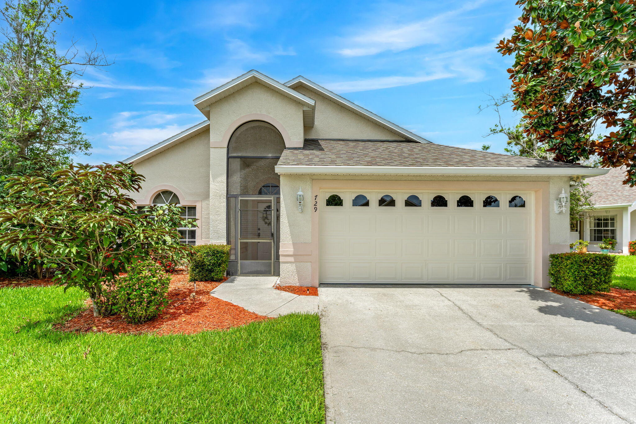 a front view of a house with a yard and garage