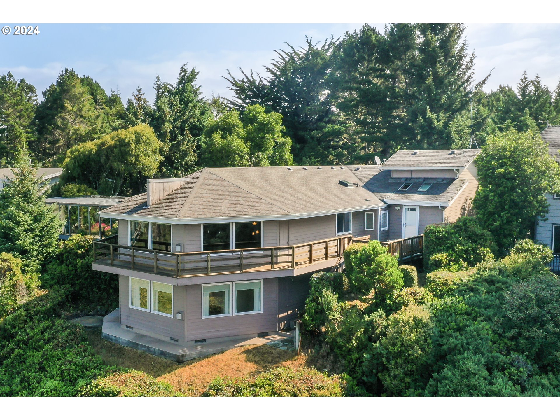 a view of a big house with a big yard plants and large trees