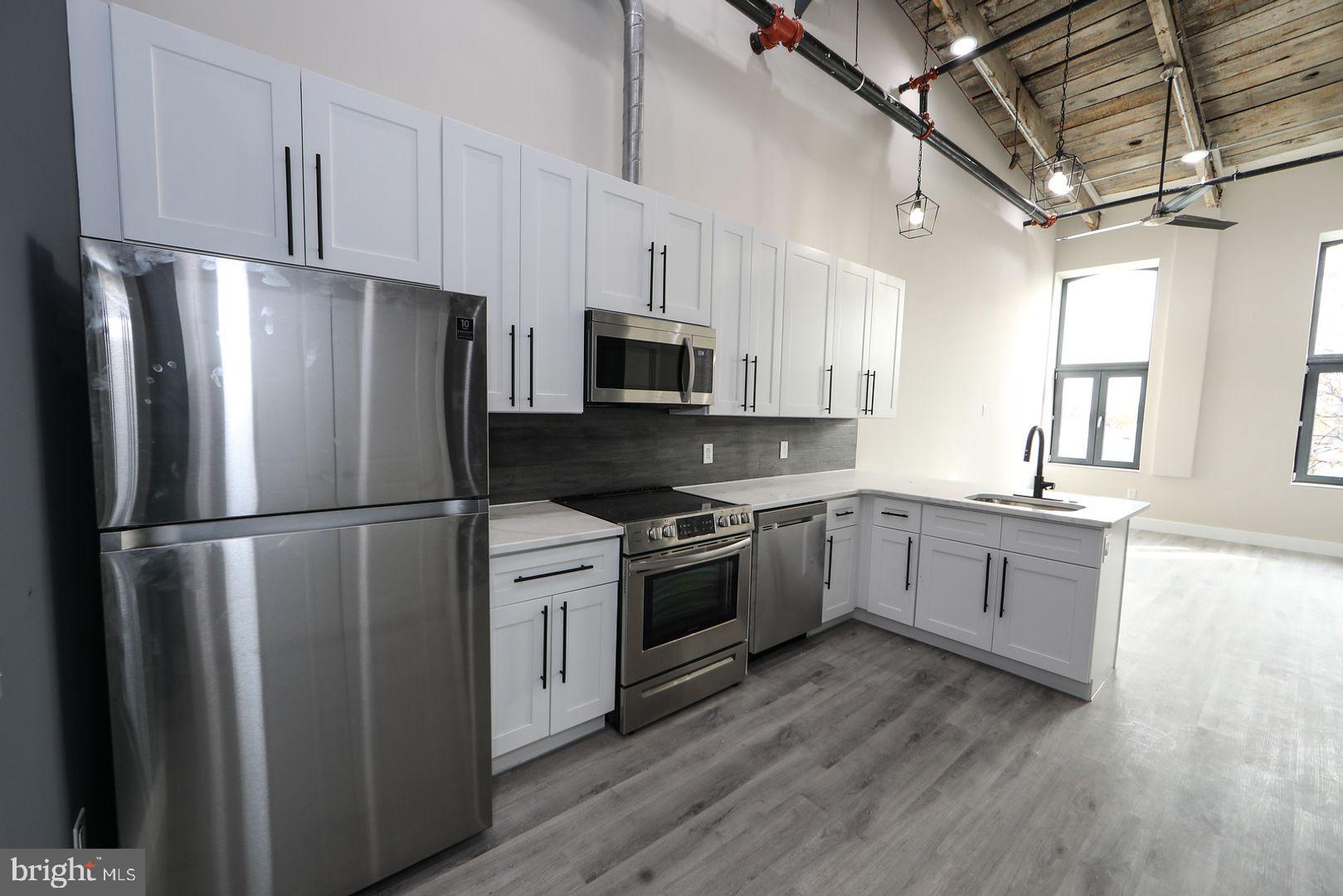 a kitchen with stainless steel appliances a refrigerator sink and microwave