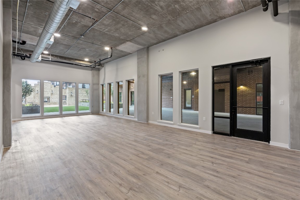 a view of an empty room with glass door and windows