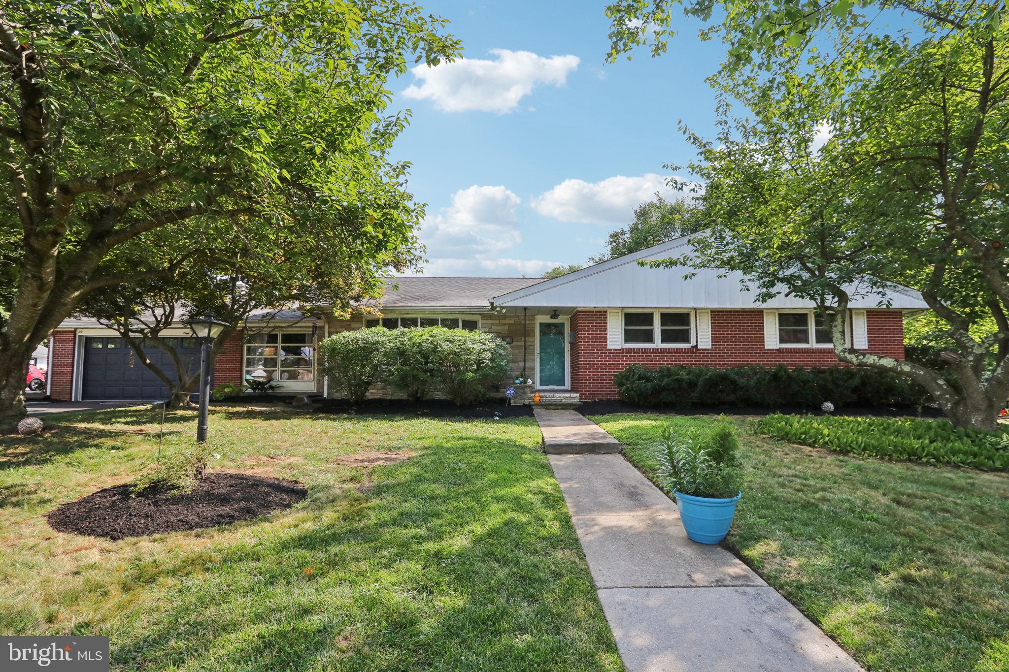 a front view of a house with a yard garage and tree