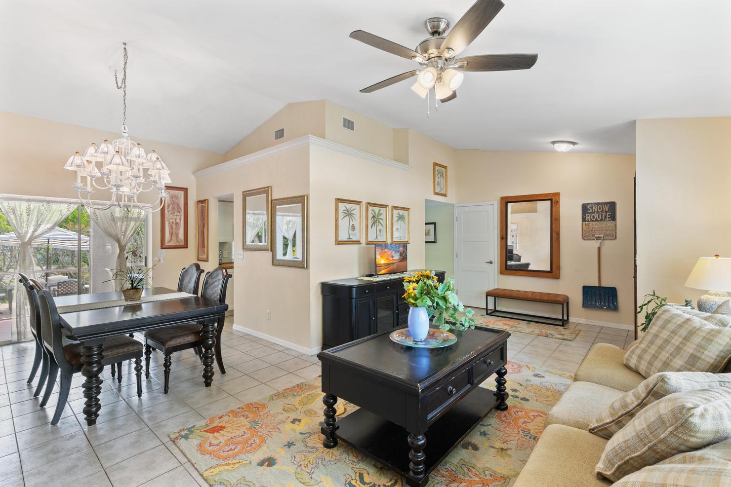 a living room with furniture a chandelier and a table