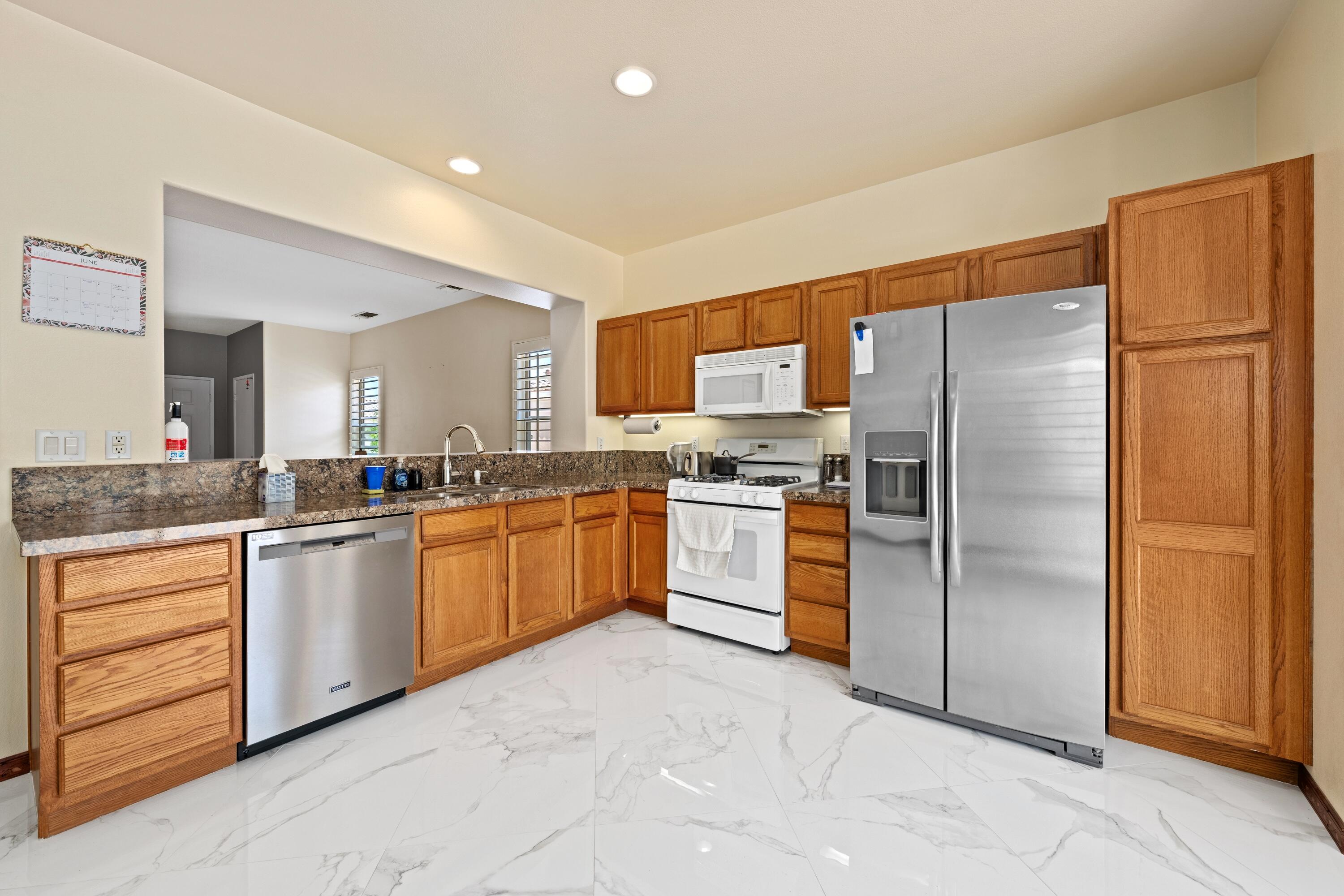 a kitchen with granite countertop stainless steel appliances and white cabinets