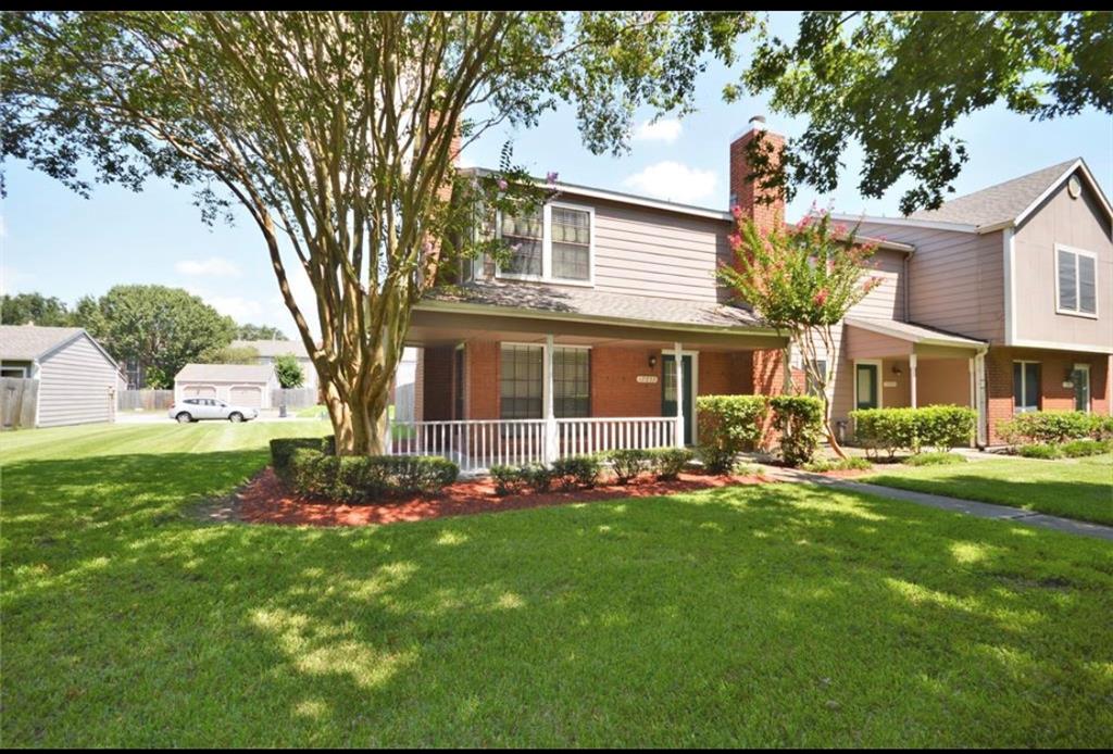 a front view of a house with a garden and trees