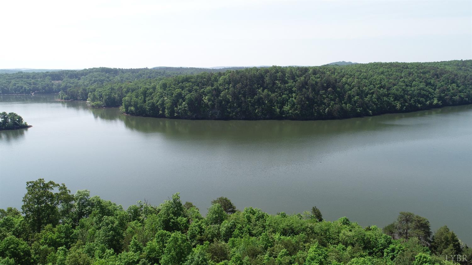 an aerial view of a house with a yard and a lake view