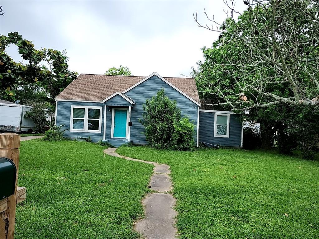 a front view of a house with a garden and yard