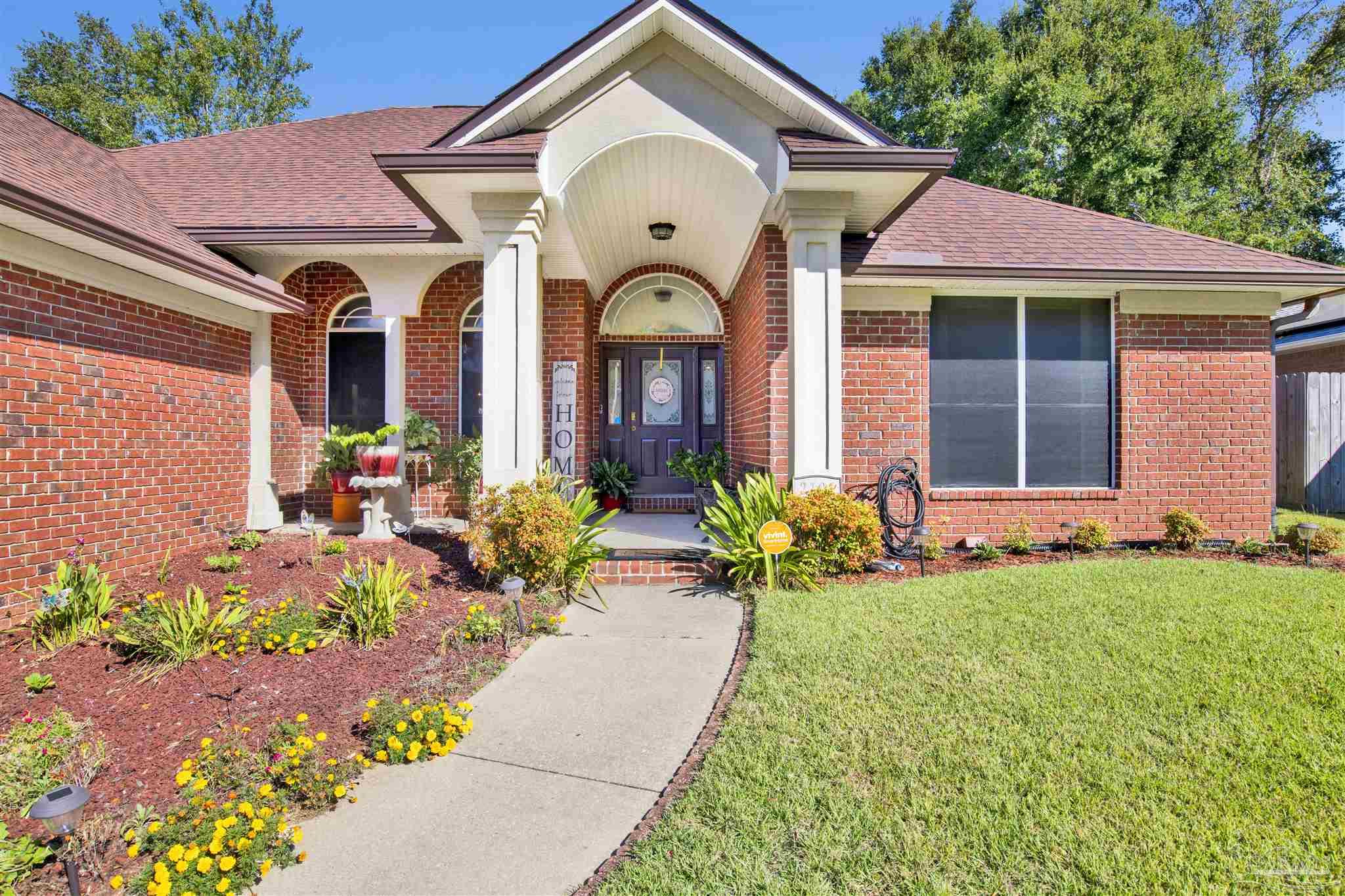 a front view of a house with a garden