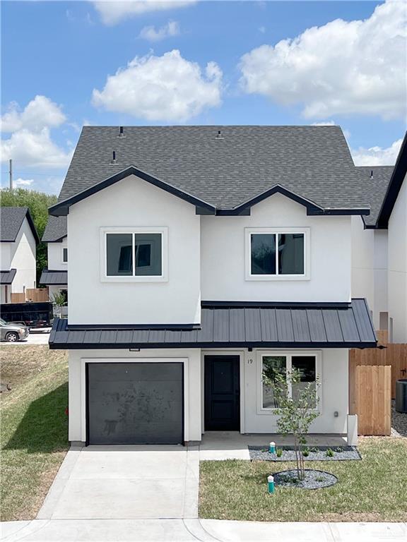 View of front of home featuring a garage, central AC, and a front yard