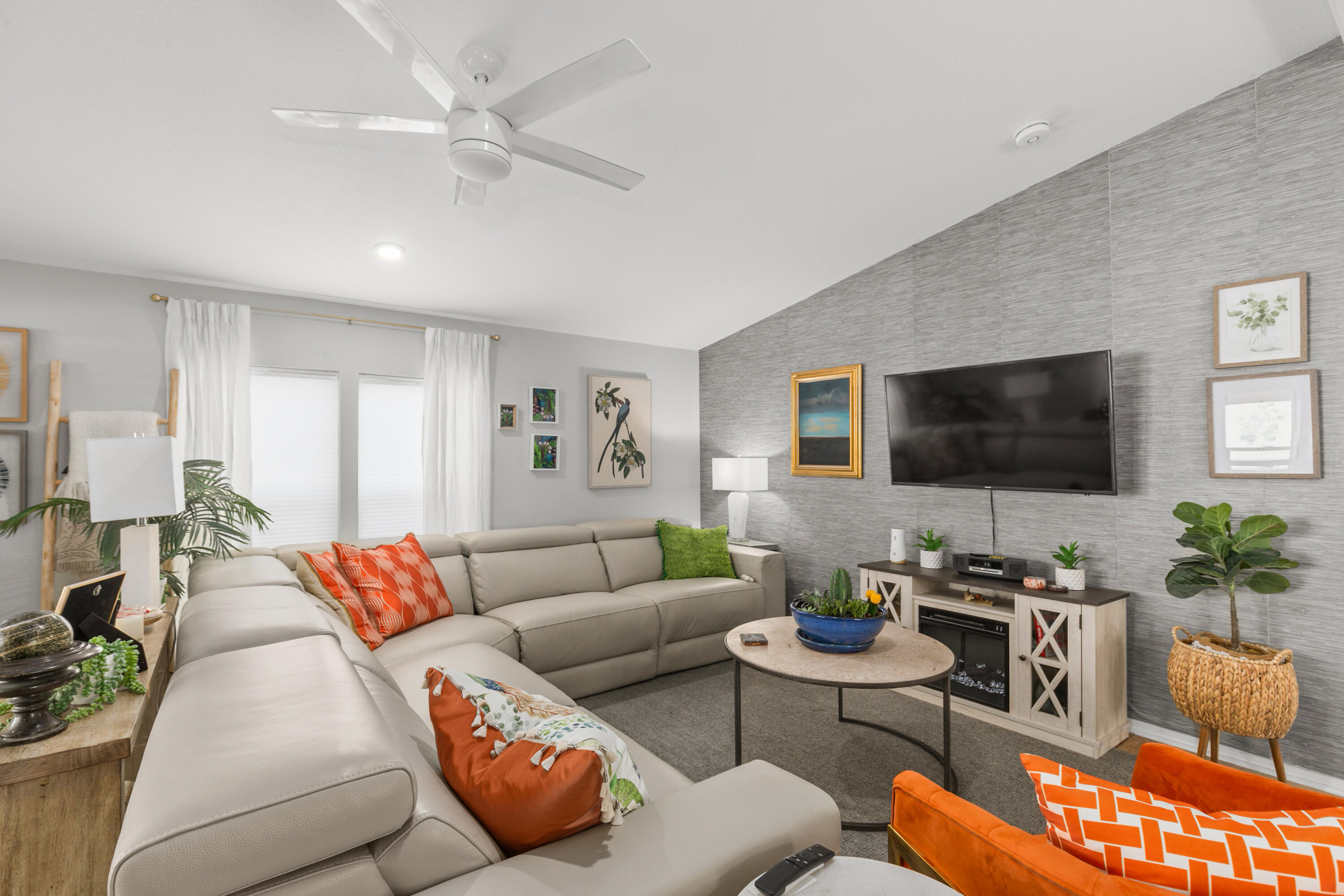 a living room with furniture a flat screen tv and a window