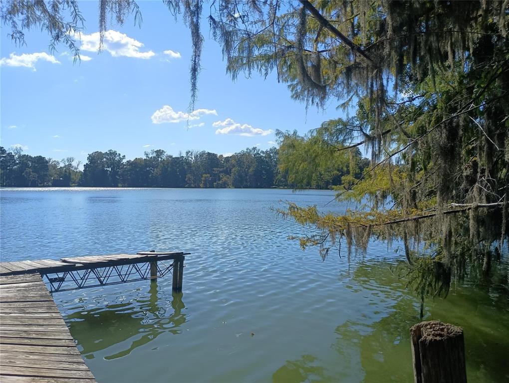 a view of a lake with a floor to ceiling window and outdoor seating