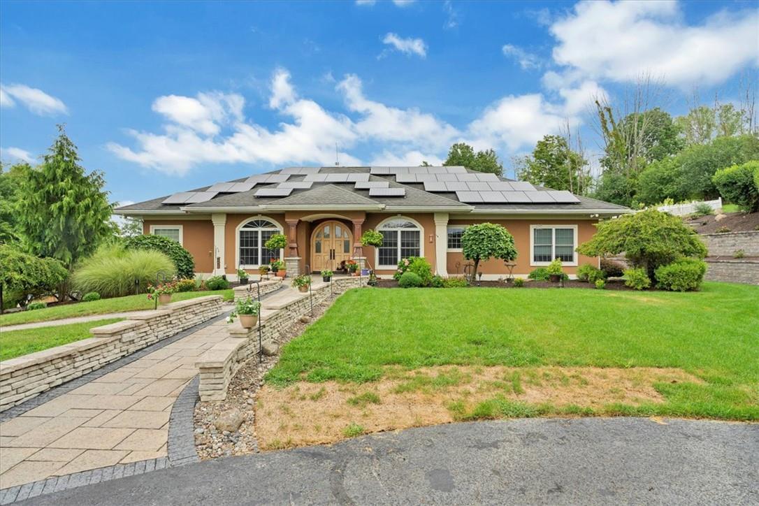 a view of house in front of a big yard with large trees